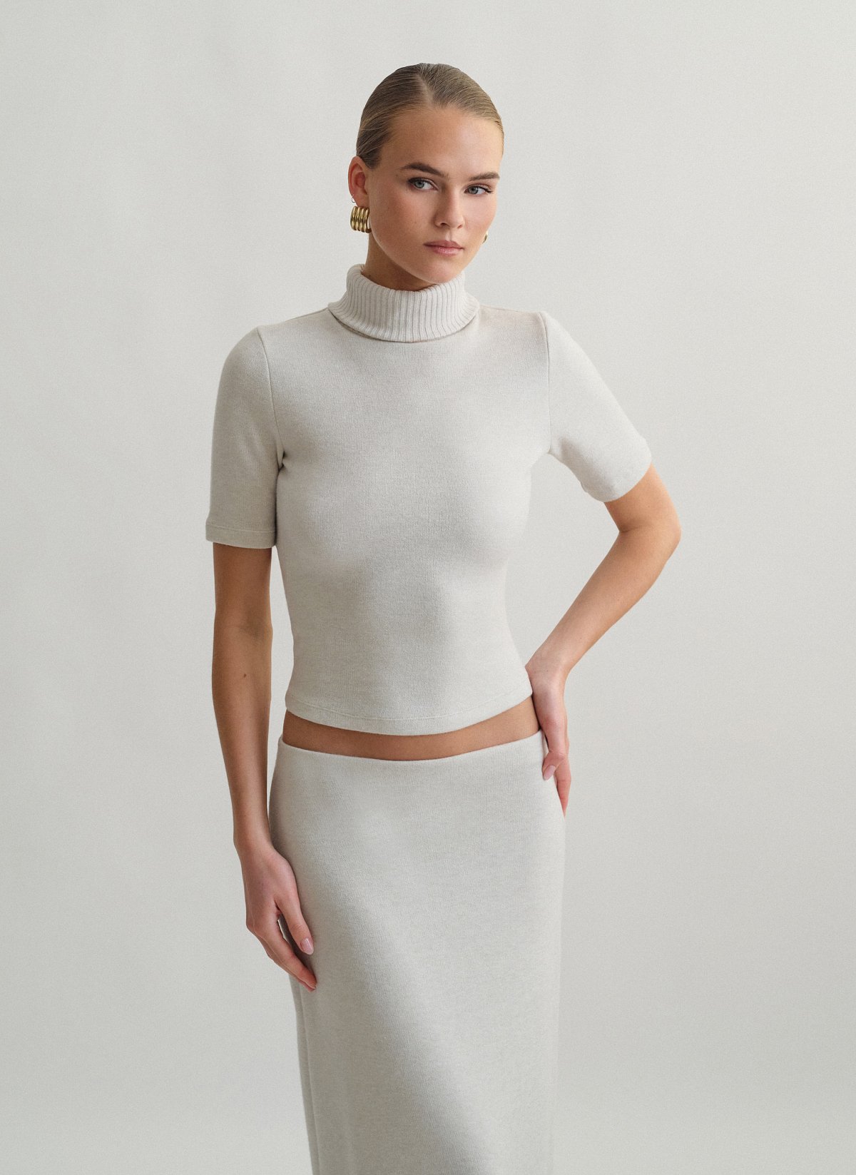 Γυναικεία πλεκτή κοντομάνικη μπλούζα με γυριστό γιακά ζιβάγκο και ανοιχτή πλάτη