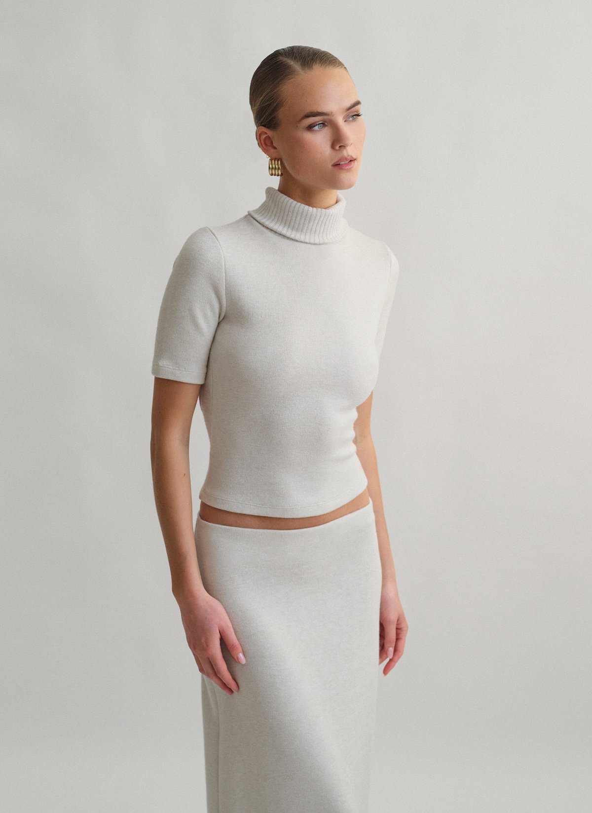 Γυναικεία πλεκτή κοντομάνικη μπλούζα με γυριστό γιακά ζιβάγκο και ανοιχτή πλάτη