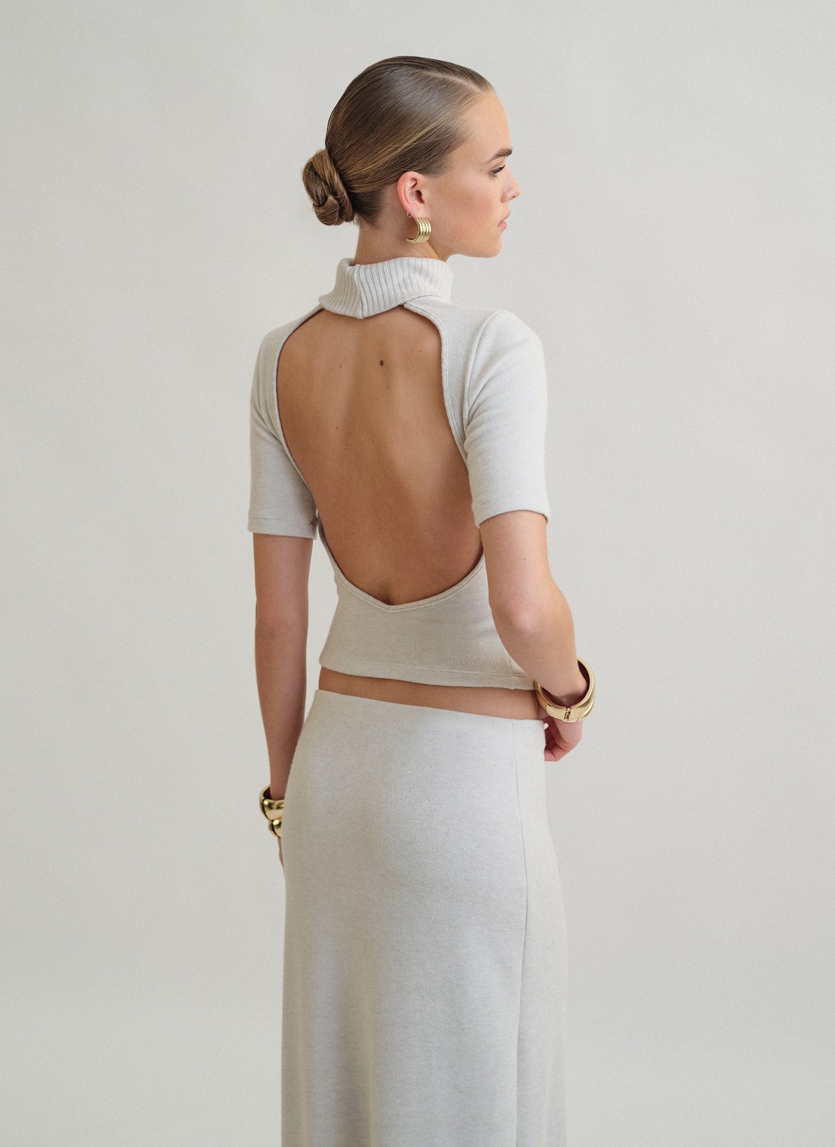 Γυναικεία πλεκτή κοντομάνικη μπλούζα με γυριστό γιακά ζιβάγκο και ανοιχτή πλάτη